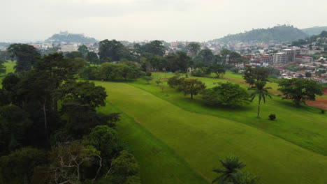 Aerial-view-flying-over-a-Golf-course-in-Yaounde-city,-cloudy-day-in-Cameroon