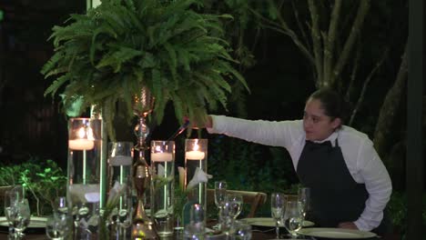 The-waitress-lights-the-candles-to-decorate-a-table-for-an-evening-wedding-reception
