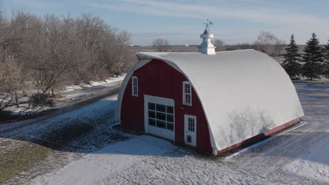 Snow-Covered-Red-Farm-Barn-in-the-Rural-Countryside,-Aerial