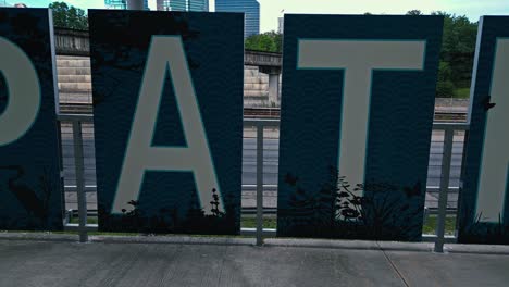 Path-400-Sign-on-railing-in-front-of-american-highway-with-driving-cars