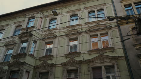 Beautiful-Hungarian-architecture,-the-facade-of-an-old-renovated-building-in-Budapest,-Hungary,-the-exterior-of-a-residential-building,-facade-design,-large-windows,-late-afternoon-in-the-city