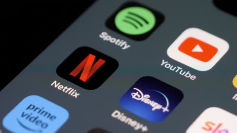Smartphone-Bildschirm-Mit-Fokus-Auf-Netflix-App-Unter-Anderem,-Benutzer-Wischt-Durch-Apps,-Technisch-Versiert,-Modernes-Leben