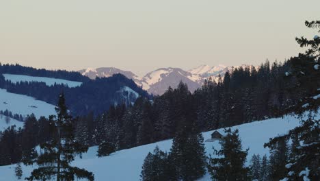 Drohnenperspektive,-Die-Den-Sonnenaufgang-über-Einer-Silhouette-Schneebedeckter-Berge-Einfängt