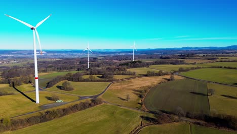 Windräder-Dominieren-Die-Ländliche-Landschaft-Unter-Einem-Klaren-Blauen-Himmel