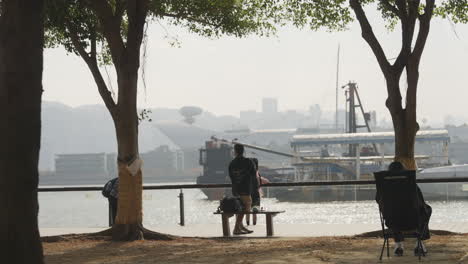 Las-Actividades-De-Los-Residentes-En-La-Orilla-Del-Río-En-La-Zona-Peatonal,-Hong-Kong,-China