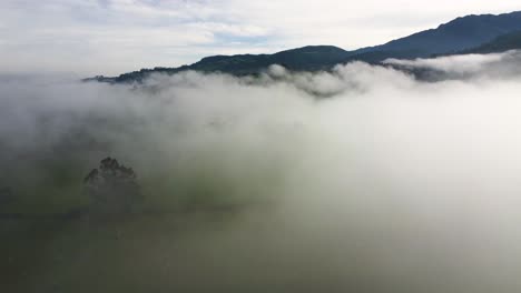 Dichter-Nebel-Auf-Einer-Großen-Grasfläche-Mit-Hügeln-Im-Hintergrund