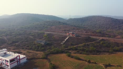 Aerial-Drone-shot-of-a-abandoned-railway-station-building-with-a-hilly-village-landscape-in-background-in-Madhya-Pradesh-India