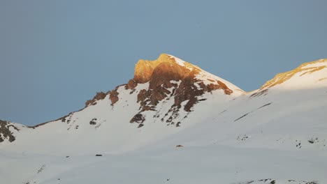 Drone-captured-sunrise-aerial-view-revealing-the-majestic-silhouette-of-a-snowy-mountain-range