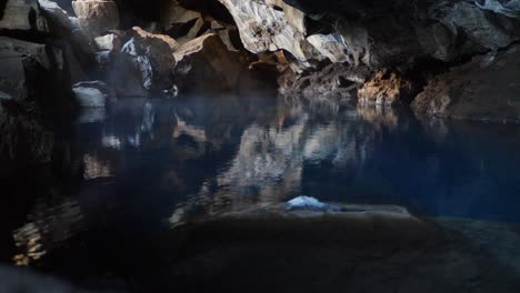 Misty-volcanic-cave-reflecting-in-serene-water-in-Iceland's-Dimmuborgir,-no-people,-tranquil-scene