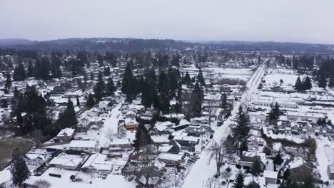 aerial-shot-of-cars-driving-down-icy-road-in-small-town