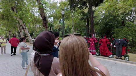 Woman-takes-picture-of-tourists-dressed-in-traditional-flamenco-clothing-near-the-Plaza-de-España