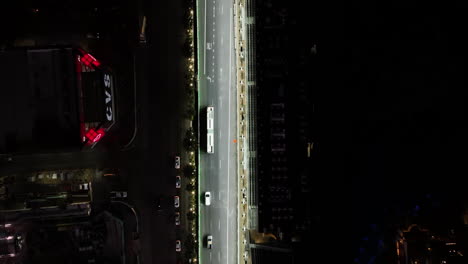 Top-down-drone-shot-following-a-bus-on-the-illuminated-Las-Vegas-Boulevard