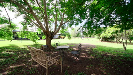 Push-In-Dolly-to-Luxurious-Rural-Estate-Outdoor-Garden-Metal-Seating-Area-With-Table-Bench-and-Chairs