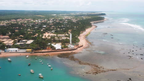 Vista-Aérea-De-La-Playa-Praia-Do-Forte,-El-Arrecife-De-Coral,-Barcos-Estacionados,-área-De-Palmeras-En-Un-Día-Nublado,-Praia-Do-Forte,-Bahia,-Brasil