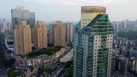 Paisaje-Urbano-Moderno-Al-Atardecer-Con-Edificios-Iluminados,-Carteles-Y-Calles-Concurridas-En-China,-Vista-Aérea
