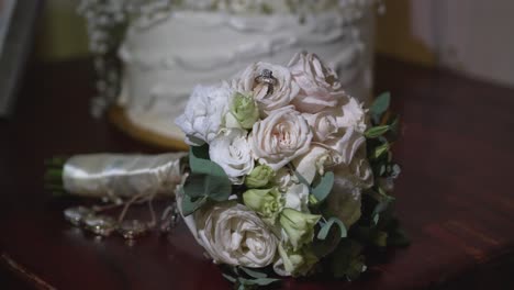 Shiny-white-gold-wedding-rings-among-the-rose-petals-of-the-bride's-bouquet