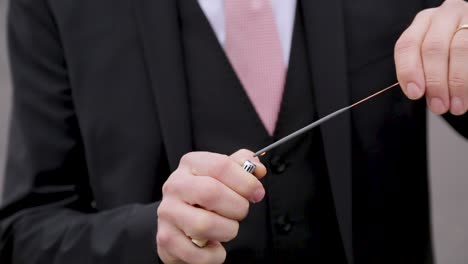 Man-in-suit-lighting-sparkler,-close-up-of-hands,-selective-focus