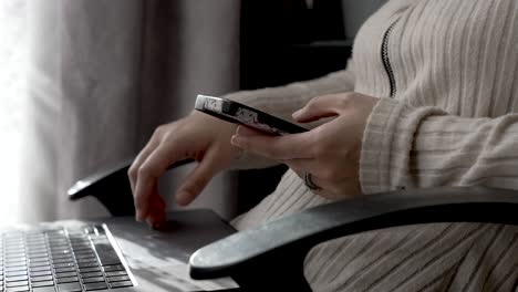 Close-Up-Of-Female-Hand,-Scrolling-On-Mobile-With-Laptop-On-Lap