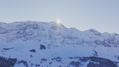 Luftaufnahme-Einer-Drohne,-Die-Die-Silhouette-Schneebedeckter-Gipfel-Bei-Sonnenaufgang-Einfängt