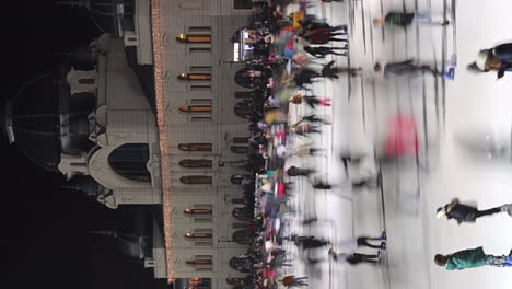 Vertical---Multitud-De-Personas-En-La-Pista-De-Hielo-Del-Parque-De-La-Ciudad-Por-La-Noche-En-Budapest,-Hungría