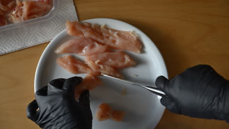 Woman-cutting-chicken-meat-into-slices-on-a-plate