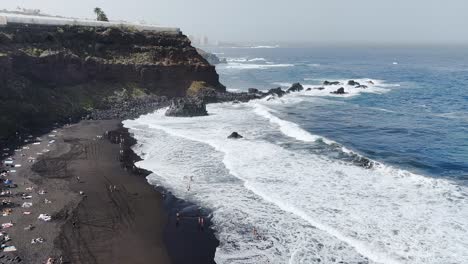 Breaking-waves-at-a-black-sand-beach-on-a-sunny-day