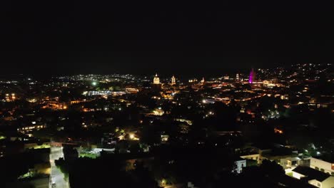 City-Of-San-Miguel-de-Allende,-Mexico-With-Illuminated-Lights-At-Nighttime---Aerial-Drone-Shot
