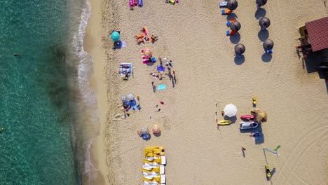 Strand-Von-Cala-Mesquida-Mit-Bunten-Sonnenliegen-Und-Sonnenschirmen,-Insel-Mallorca,-Spanien,-Sonniger-Tag,-Luftaufnahme
