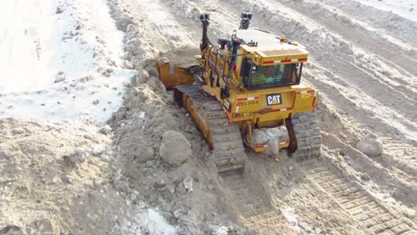 Las-Orugas-De-La-Topadora-Empujan-Y-Limpian-La-Nieve-Sucia-Que-Se-Derrite-Para-Despejar-Las-Carreteras-De-Acceso-En-Montreal,-Canadá