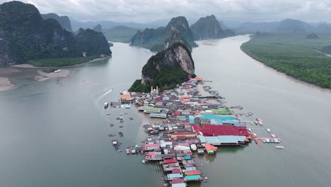 Aerial-footage-of-Ko-Panyi,-a-floating-village-in-Thailand,-showcasing-its-unique-architecture-and-stunning-coastal-views