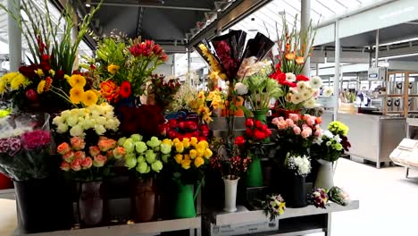 Stand-with-vibrant-colorful-flowers-in-black-vases-at-Bolhao-Market,-Porto
