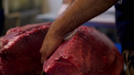 Zeitlupen-Nahaufnahme-Eines-Männlichen-Kochs,-Der-Ein-Großes-Stück-Rotes-Fleisch-Eines-Frischen-Blauflossenthunfischs-In-Zwei-Hälften-Schneidet
