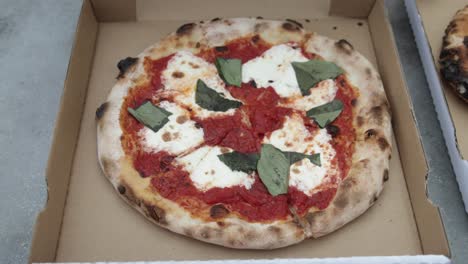 Cooked-Margherita-pizza-in-a-take-out-box-with-someone-opening-box-from-Pizzeria-Bianco-in-Phoenix,-Arizona-with-stable-video