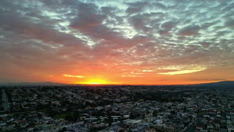 Vista-Aérea-De-La-Ciudad-Iluminada-Por-Una-Impresionante-Puesta-De-Sol,-El-área-Urbana-Se-Fusiona-Perfectamente-Con-La-Naturaleza