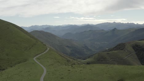 Coches-Circulando-Por-La-Carretera-Panorámica-De-Col-Inharpu-Con-La-Cordillera-Al-Fondo,-Pirineo-Vasco,-Francia