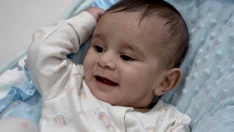 Sechs-Monate-Altes-Britisch-asiatisches-Baby,-Das-Ausdrucksstark-Und-Lächelnd-Im-Korb-Liegt-Und-Neugier-Und-Entspannung-Zeigt