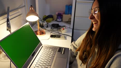 Green-screen-on-laptop-of-cute-woman-laughing-and-waving-at-person-on-video-call,-ready-to-key