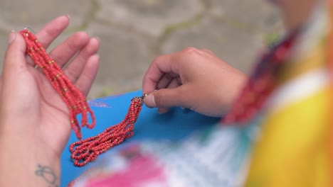 Slow-motion-cinematic-clip-of-a-young-woman-resting-her-long-red-earrings-on-the-traditional-costume-of-Cayambeñas-in-Ecuador