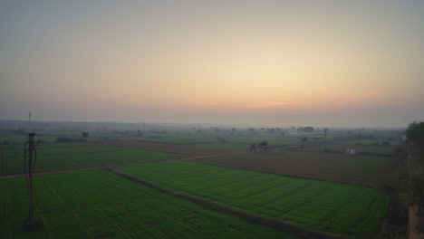 Zeitraffer-Des-Sonnenuntergangs-Mit-Grünen-Feldern-Im-Vordergrund-In-Einem-Dorf-Im-Ländlichen-Madhya-Pradesh-In-Indien
