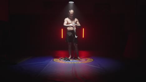 Typ-Legt-Bandagen-Zum-Kämpfen-An,-Boxhandbandagen-Im-Dojo,-Kampfsporttraining