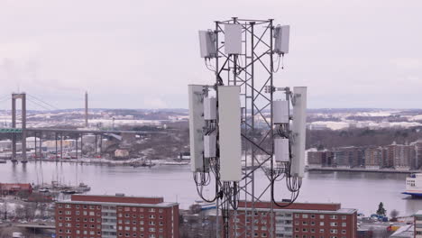 Toma-Aérea-De-Una-Antena-De-Telefonía-Móvil-5G-En-Gotemburgo-Con-Älvsborgsbron-Detrás