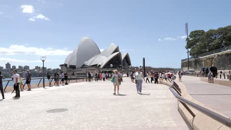 Weite-Aufnahme-Von-Menschen,-Die-An-Einem-Sonnigen-Tag-Am-Berühmten-Sydney-Opera-House,-Einem-Architektonischen-Weltwunder,-Vorbeigehen,-New-South-Wales,-Australien