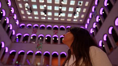 Woman-amazed-by-vibrant-purple-Fondaco-dei-Tedeschi-arches-in-Venice-mall