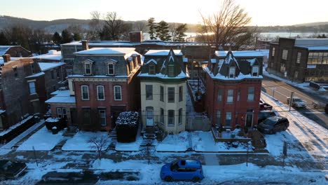 Victorian-houses-at-sunset-with-snowy-roofs-and-a-river-in-the-background