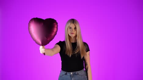 Concept-valentine's-day,-young-woman-holds-red-heart-balloon-heart-at-the-camera