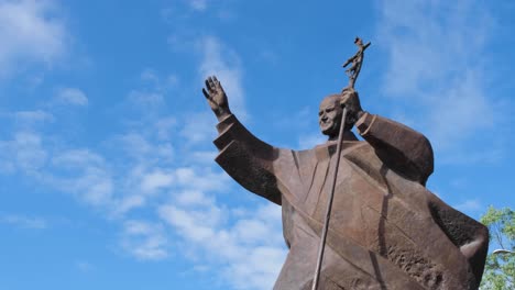 Side-view-of-bronze-statue-of-Pope-John-Paul-II-against-blue-sky-in-the-capital-city-of-East-Timor,-Southeast-Asia