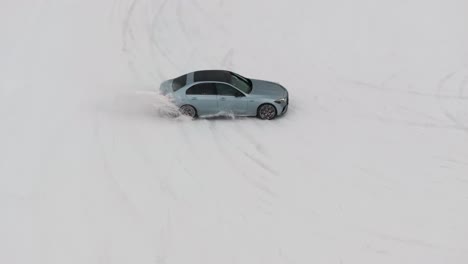 Aerial-view-on-car-drive-around-traffic-cones-on-snowy-race-track,-drift-event