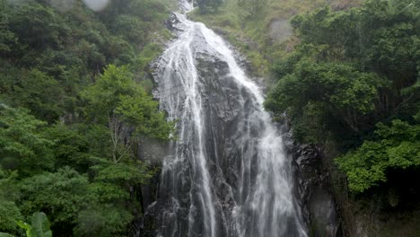 Lush-Efrata-waterfall-cascading-down-rocky-cliff-surrounded-by-green-foliage-near-Lake-Toba