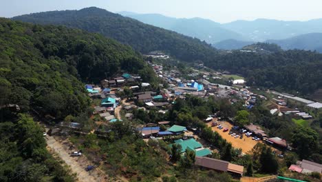 Slow-drone-rotating-shot-over-typical-mountain-village-in-Thailand-with-market