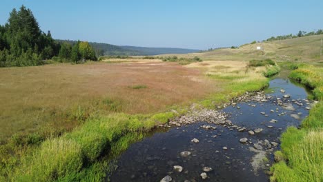 Un-Dron-Aéreo-Asciende-Por-Encima-Del-Arroyo-A-Lo-Largo-De-La-Autopista-Cariboo-Cerca-De-La-Casa-De-127-Millas,-BC,-Canadá